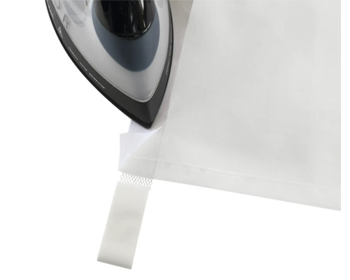 Žehlička žehlí okraj záclony