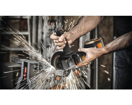 Muž brúsi kov akumulátorovou uhlovou brúskou, odlietajú iskry