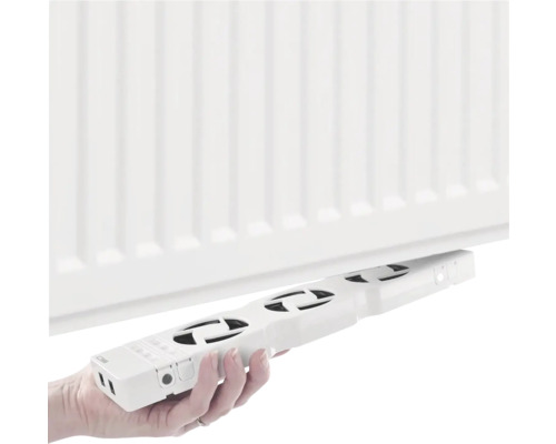 Osoba drží ventilátor radiátora pod radiátorom.