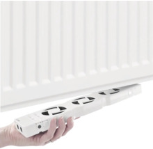 Ruka montuje chladič ventilátora na radiátor.