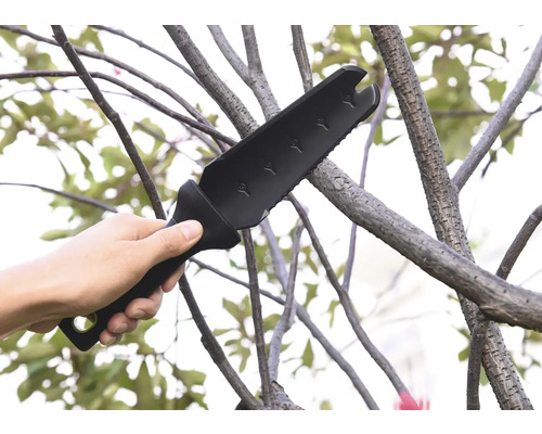 Ruka drží multifunkčnú záhradnú sekeru používanú na konári