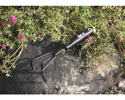 Záhradný kultivátor na kameni medzi rastlinami