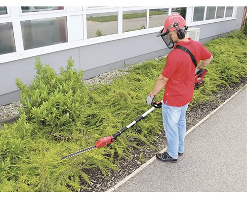 Osoba strihá živý plot nožnicami na živý plot
