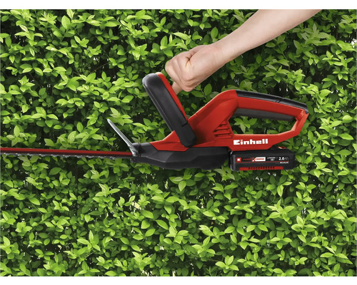 Akumulátorové nožnice na živý plot Einhell v prevádzke pred zeleným živým plotom