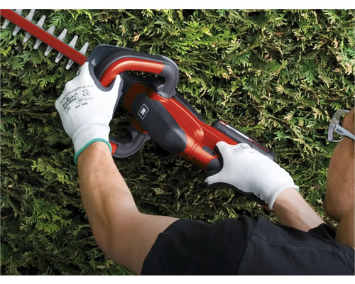 Osoba používa nožnice na živý plot na prerezávanie živého plota