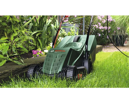 Kosačka na trávu používaná v záhrade medzi rastlinami