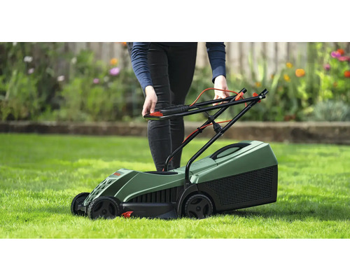 Osoba obsluhuje zelenú kosačku na trávniku.