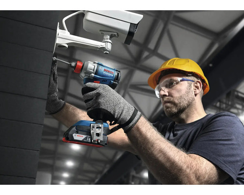 Muž s ochrannými okuliarmi a helmou upevňuje bezpečnostnú kameru pomocou akumulátorového rázového uťahovača Bosch.