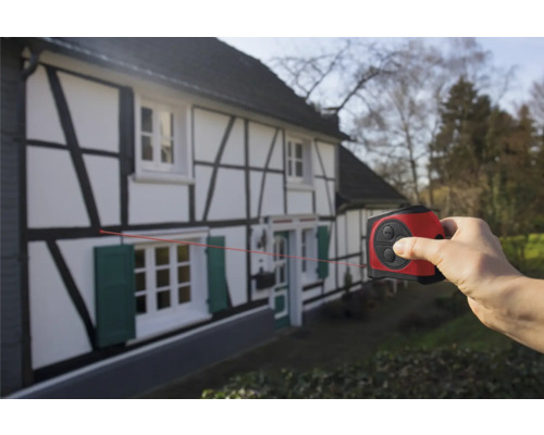 Ruka používa laserový diaľkomer na hrázdenom dome