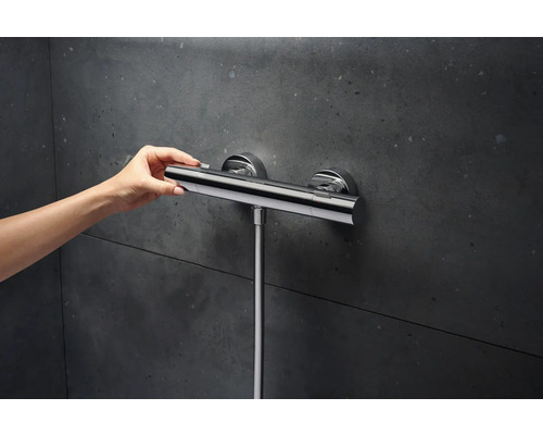 Nástenný sprchový termostat s ručným ovládaním pred tmavou stenou