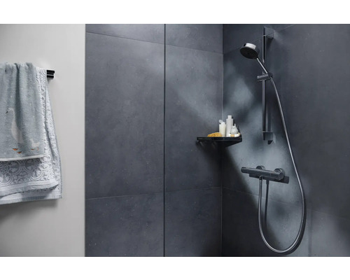 Moderná kúpeľňa so sprchou, poličkou a uterákmi