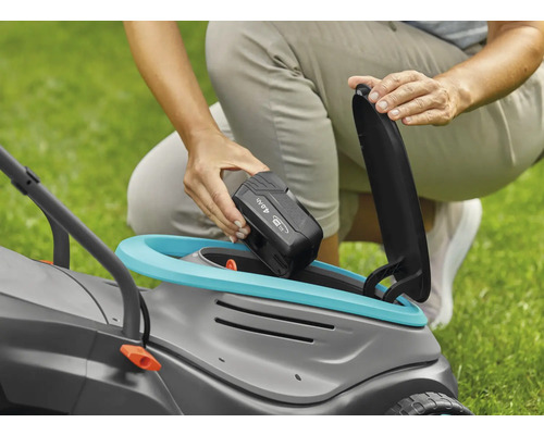 Osoba vkladá 4,0 Ah batériu do kosačky na trávu