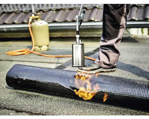 Strechár zvára bitúmenový pás s horákom a plynovou fľašou.