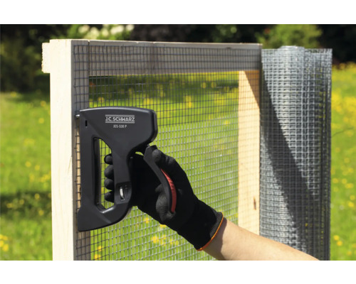 Osoba pripevňuje drôtené pletivo ku drevenému rámu pomocou sponkovačky J.C. Schwarz JCS-530 P