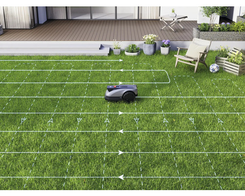Robotická kosačka kosí trávnik v záhrade s terasou.