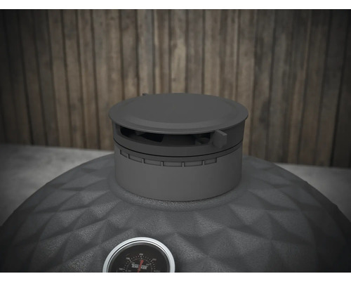 Pohľad zhora na gril na drevené uhlie s ukazovateľom teploty.