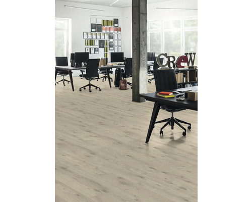 Svetlá kancelária s drevenou podlahou, stolmi a kancelárskymi stoličkami.