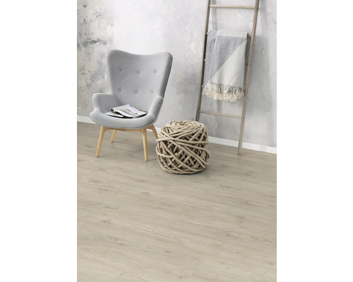 Obývacia izba s kreslom, pletenou loptou a dreveným rebríkom s dekou na laminátovej podlahe