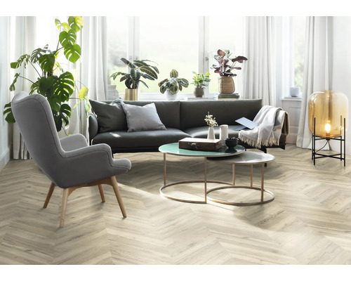 Obývacia izba so sivou pohovkou, kreslom a dekoratívnymi predmetmi na stole