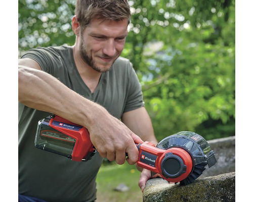 Muž používa akumulátorovú čističku škár Einhell na čistenie kamenného povrchu.