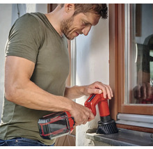 Muž čistí okno pomocou akumulátorovej čistiacej kefy.