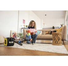 Žena čistí koberec čistiacim vysávačom Kärcher vo svetlej obývačke