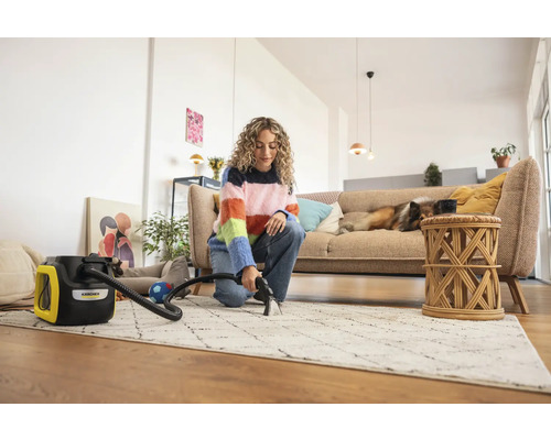 Žena čistí koberec čistiacim vysávačom Kärcher vo svetlej obývačke