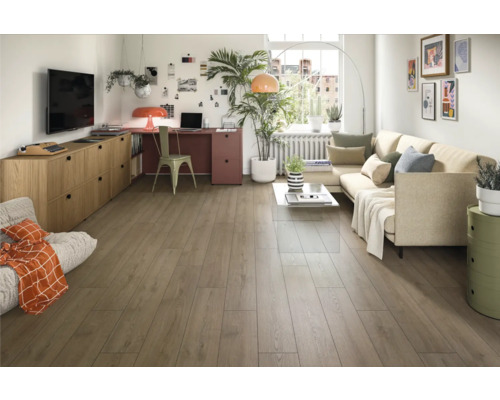 Svetlá obývacia izba s drevenou podlahou, pohovkou, písacím stolom a dekoráciami pre útulnú atmosféru.