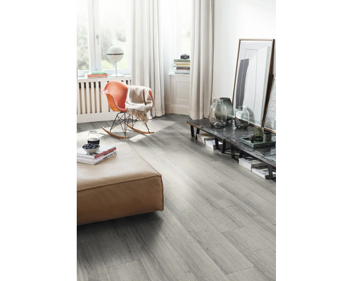 Obývacia izba so sivou laminátovou podlahou, taburetkou a hojdacím kreslom.