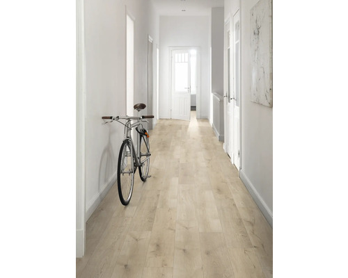 Chodba so svetlou drevenou podlahou, bielymi stenami a bicyklom