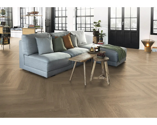 Obývacia izba s parketovou podlahou vo vzore rybej kosti, pohovkou a drevenými stolmi.