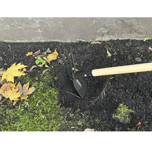 Motyka s drevenou násadou v záhone