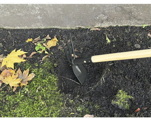 Motyka s drevenou násadou v záhone