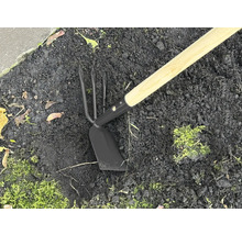 Záhradné náradie s drevenou násadou a kovovou hlavou v zemi