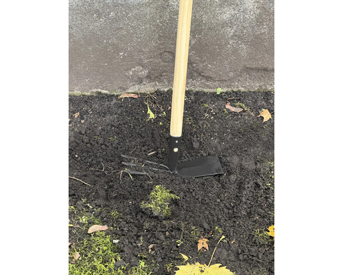 Záhradná motyka s drevenou násadou v zemi