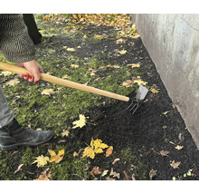 Práca na záhrade s kombinovanou motykou na spracovanie pôdy