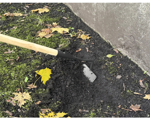 Záhradná motyka s drevenou násadou používaná v záhradnej pôde.