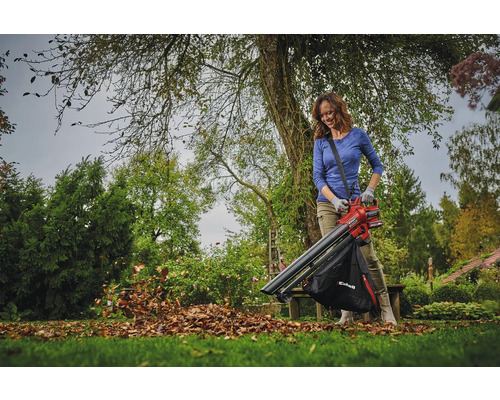 Žena používa na záhrade vysávač lístia na odstraňovanie lístia.