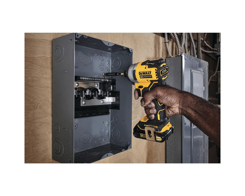 Muž pripevňuje istič k stene pomocou akumulátorového rázového uťahovača.