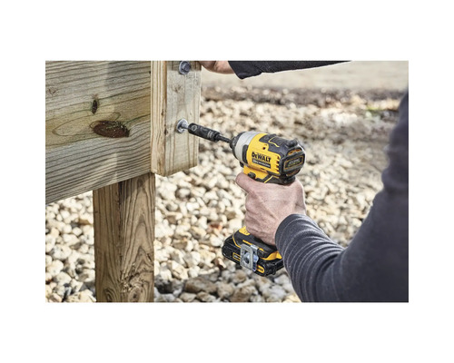 Osoba používa akumulátorový rázový uťahovák na zaskrutkovanie skrutky do kusa dreva.