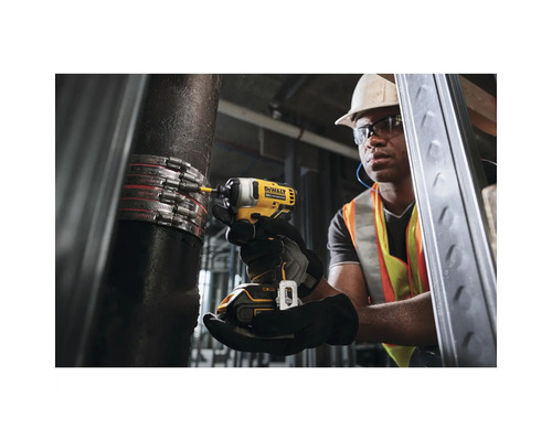 Remeselník upevňuje rúrkovú sponu na rúrku pomocou akumulátorového rázového uťahovača.