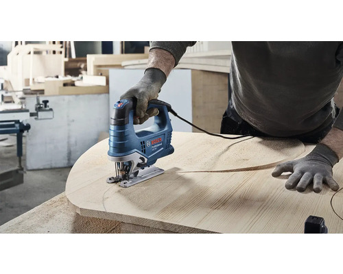 Osoba reže drevenú dosku priamočiarou pílou. Logo Bosch.
