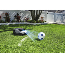 Robotická kosačka na trávniku s futbalovou loptou