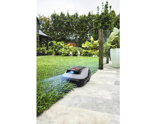 Robotická kosačka na trávniku a kamenných doskách