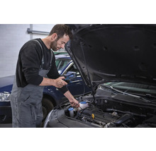 Mechanik vykonáva diagnostiku motora automobilu pomocou diagnostického zariadenia.