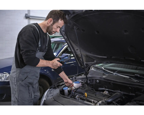 Mechanik vykonáva diagnostiku motora automobilu pomocou diagnostického zariadenia.