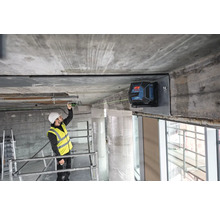 Stavebný robotník používa čiarový laser na vyrovnanie na stavenisku.