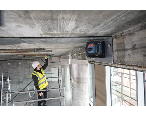 Stavebný robotník používa čiarový laser na vyrovnanie na stavenisku.