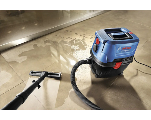 Modrý a čierny mokro-suchý vysávač Bosch čistí dlaždenú podlahu