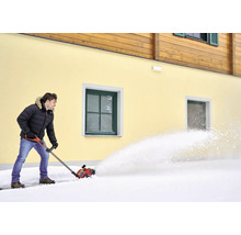 Muž odpratáva sneh snehovou frézou pred domom